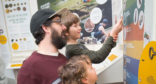  A family looks at an exhibit on the wall.